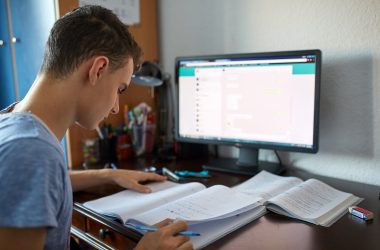 Teenager boy doing homework on his desk at home